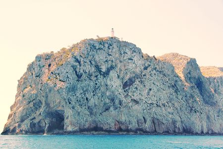 Gorgeous cliff in the Mediterranean sea with Lighthouse on the top. Turquoise sea water and blue sky. Spain. Palma de Majorka. Beautiful nature background.の写真素材