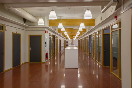 Sweden. Beautiful hall in a modern building with multiply office rooms isolated. White walls and red-brown marble polished floor. Wooden and glass parts. Business concept.の写真素材