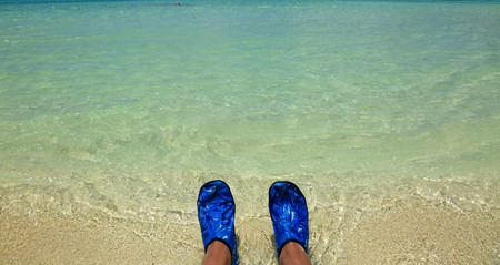 Happy feet. Vacation holidays. Pair of feet of a couple relaxing on the beach in water.の写真素材
