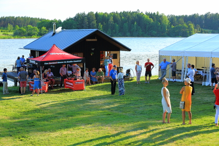 Outdoor firm party near a lake in the great summer day. Some people are playing with radio controlled cars, some are talking. Sweden, Enkoping. 9 June 2018.nのeditorial素材