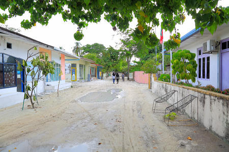 View of a narrow street in Maldives, Dhangethi Island. White sand and gray walls.の写真素材