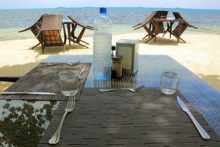 Empty outdoor restaurant on the coast of Indian Ocean. White sand and blue water. Maldives. Food and drink background.の写真素材