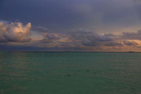 Gorgeous view of sunset on Indian Ocean, Maldives. Blue water and blue sky with white clouds. Amazing nature backgrounds.の写真素材
