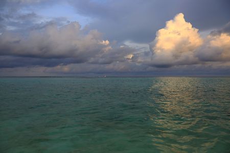 Gorgeous view of sunset on Indian Ocean, Maldives. Blue water and blue sky with white clouds. Amazing nature backgrounds.の写真素材