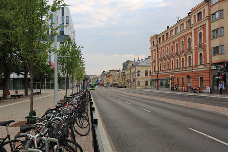 07-28-2018 :- View of main downtown street in Uppsala, Sweden, Europe. Parking lot for bicycles near a busstop, green trees and beautiful old and modern buildings.のeditorial素材
