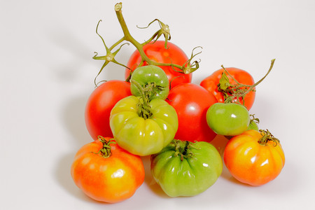 Close up view green and red tomatoes isolated. Colorful nature background.の写真素材
