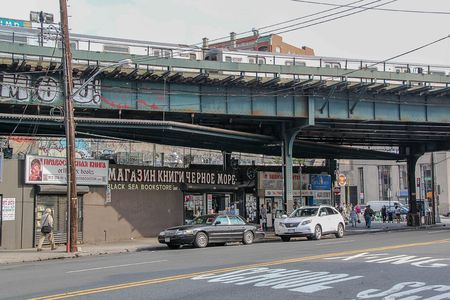 Beautiful street of Brighton Beach neighborhood. Car traffic and people concept. New York. USA.のeditorial素材