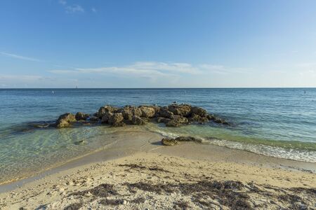 Gorgeous view of nature landscape. Seagulls on rocks on sandy coast of Atlantic ocean on blue sky background.の写真素材