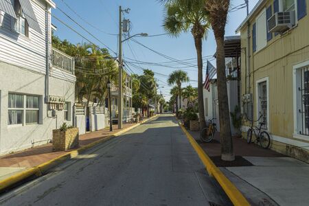 Beautiful street landscape view of one of streets in Key wet, Florida. Light houses and green palm trees on blue sky background.の写真素材