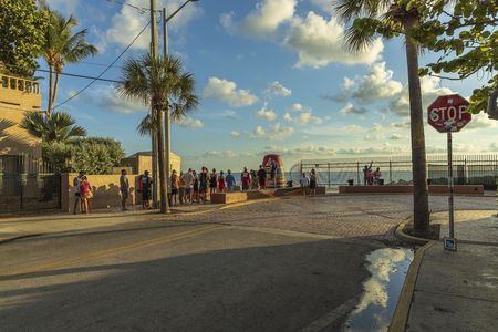 Tourists standing in line in order to take picture at famous tourist attraction Southernmost point. Key West. Florida USAのeditorial素材