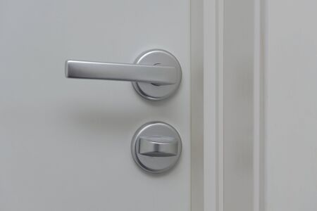 Close up view of silver door handle and white light switch isolated. Building construction elements concept.の写真素材