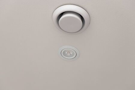 Close up view of white round ceiling vent. Building construction elements. Ventilation and Heating concept.の写真素材