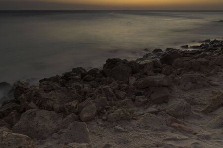 Gorgeous colorful view of sunset on Aruba. Beautiful nature landscape. Rocky coast of Atlanta, Caribbean.の写真素材