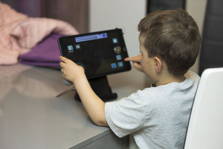 Close up view of child playing on tablet. Gadgets concept. Modern technology.
