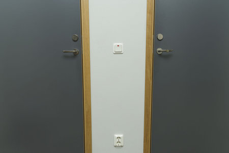 Close up view of power socket and power switch near door handle on wall and door. Interior design...