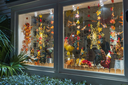 Beautiful view of shop window. Colorful figures of roosters and butterflies, leafs and flowers as...