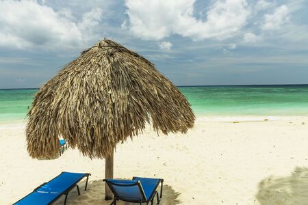 Beautiful view of white sand beach with sun umbrellas and sunbeds. Eagle beach. Aruba island.の写真素材