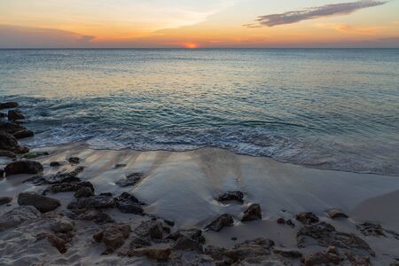 Amazing sunset on Eagle Beach of Aruba Island. Unforgettable view. Beautiful nature landscape.の写真素材