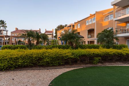 Beautiful Tamarijn hotel area view. Green bushes and plants and yellow buildings on blue sky background. Oranjestad.Aruba.のeditorial素材