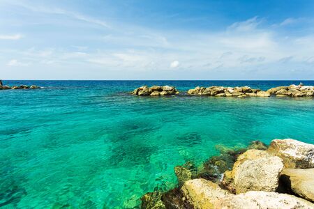 Beautiful nature landscape view. Rocky coast line. Blue water surface of Atlantic ocean merging with blue sky on Curacao island. Gorgeous nature landscape backgrounds. Caribbean.の写真素材