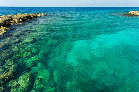Beautiful nature landscape view. Rocky coast line. Blue water surface of Atlantic ocean merging with blue sky on Curacao island. Gorgeous nature landscape backgrounds. Caribbean.の写真素材