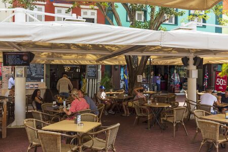 Close up view of outdoor cafe with clients at some of tables. Tourism concept. Willemstad. Curacao. 09/09/2019.のeditorial素材