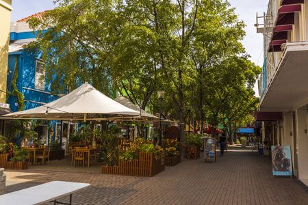 Beautiful view of outdoor cafe on one of Willemstad streets. Beautiful buildings and green trees on background. Eating out concept. Tourism concept. Willemstad. Curasao. 09.19. 2019のeditorial素材
