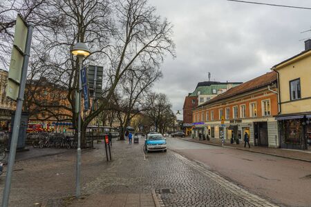View of street of Uppsala, Sweden. Sky with thunderclouds in winter day. Red buildings on sky background. Tourism, travel concept. Europe, Sweden, Uppsala. 12.30.2019.のeditorial素材