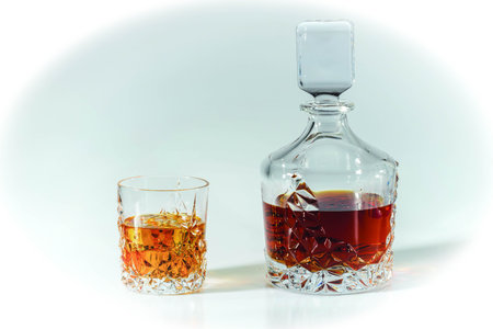 Beautiful view whiskey decanter and glass of whiskey with ice on blue background. Beautiful...
