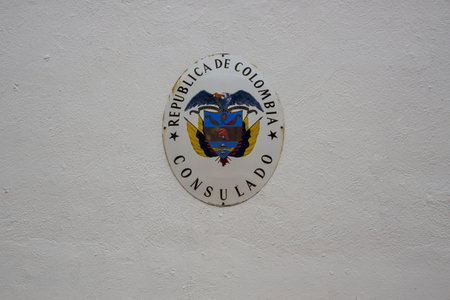 Close up view of emblem of Consulate of republic of Colombia on white wall. Willemstad. Curacao....