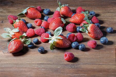 Close up view of colorful berries isolated on wooden background. Healthy food concept.の写真素材
