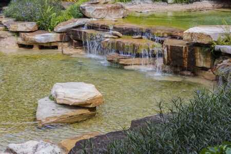 Beautiful view of pond decorated with big rocks. Clear water mirror surface effect.の写真素材