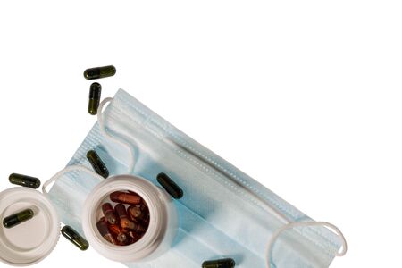Close up view of face mask and colorful pills isolated on white background. Health concept.の写真素材