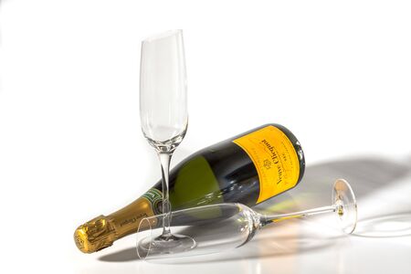 Beautiful view champagne bottle and two slim, tall and elegant champagne glasses on white background. Beautiful backgrounds. Alcohol concept. Uppsala. Sweden 02/08/2020.のeditorial素材