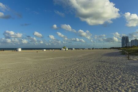 Beautiful landscape view of Miami South Beach coast line. Sand beach, Atlantic Ocean, people and high buildings on blue sky and white clouds background. USA Miami Beach.の写真素材