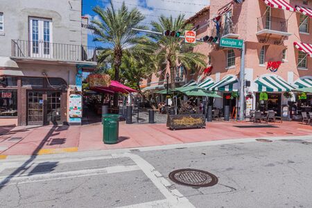 Beautiful view of outdoor cafe on one of Miami South Beach. Beautiful buildings and green trees on background. Eating out concept. Tourism concept. USA Miami South Beach. 24/09/2019.のeditorial素材