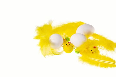 Close up view of white eggs and yellow feathers and chick figures isolated on white background. Easter conceptの写真素材