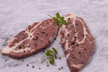 Close up view of raw pork steaks with spices isolated. Food conceptの写真素材