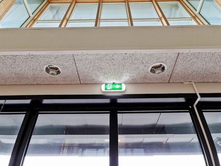 Close up view of green white wall and ceiling light, emergency exit light.の写真素材