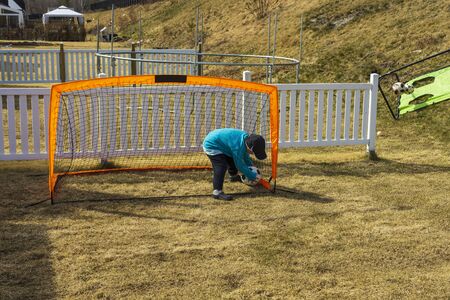 Close up view of boy playing football on backyard. Stay at home. Outdoor games concept. COVID 19の写真素材