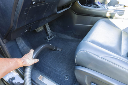 Close up view of male hand with vacuuming car.