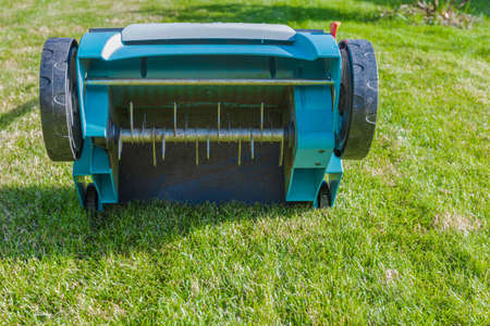 Close uo view of electric lawn aerator on green grass isolated. Garden machines concept.の写真素材