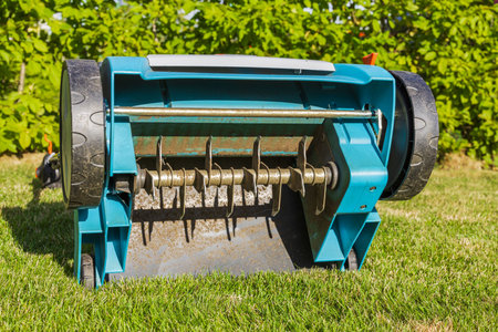 Close uo view of electric lawn aerator on green grass isolated. Garden machines concept.