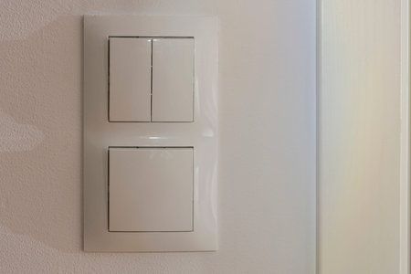Close up view of white light switch pair on wall. Building construction elements concept. Interior....