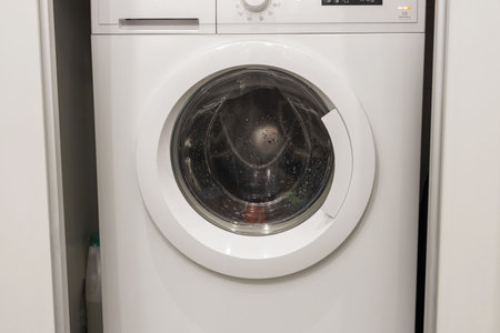 Close up view of laundry spinning in washing machine isolated. Home appliances concept.