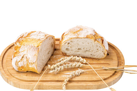 Close up view of white loaf wheat bread on wooden cutting board on white background.