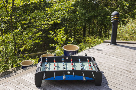 Close up view of old table football game on wooden patio. Home games concept.