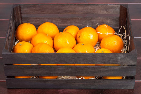 Close up view of wooden box of fresh mandarins isolated. Health and fruits concept.の写真素材