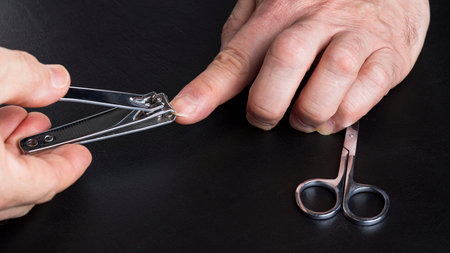 Close up view of male taking care of his own nails. Manicure concept.の写真素材
