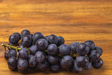 Close up view grapes isolated on wooden background